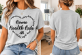 A woman modeling a light heather gray short-sleeve graphic T-shirt, shown from both the front and back. The front features a black circular text graphic reading 'Home Health Aide' with smaller surrounding words.